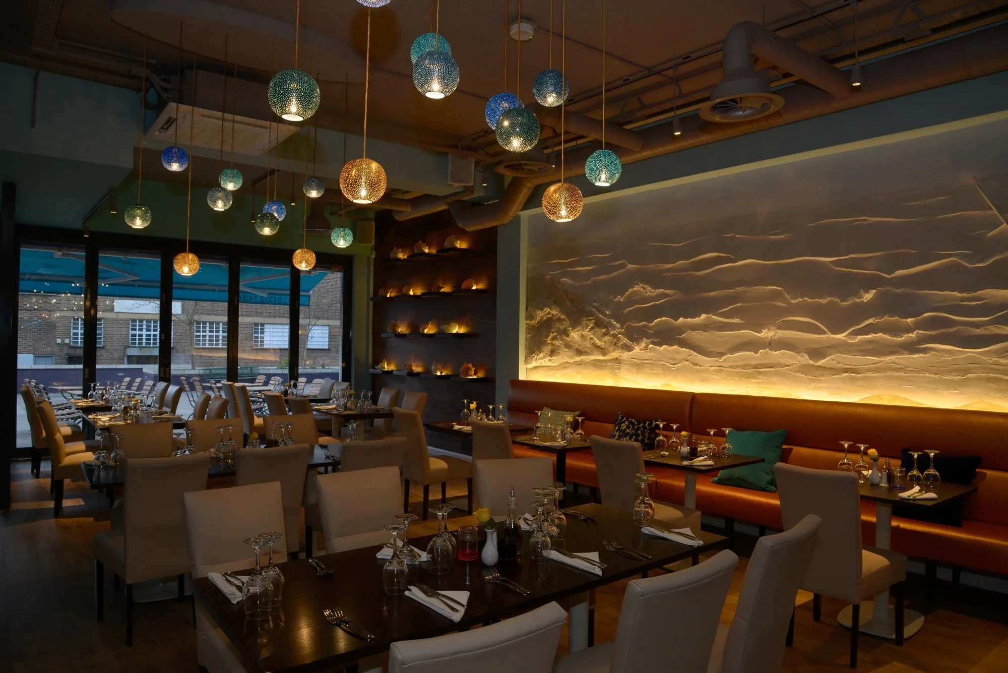 Restaurant interior with illuminated surfaces and pendant fittings