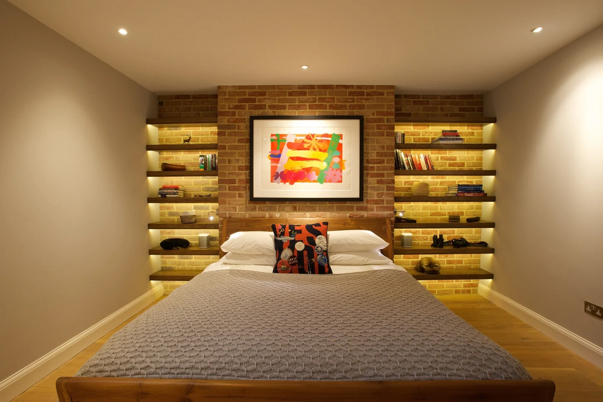 Bedroom with warmly illuminated display shelving