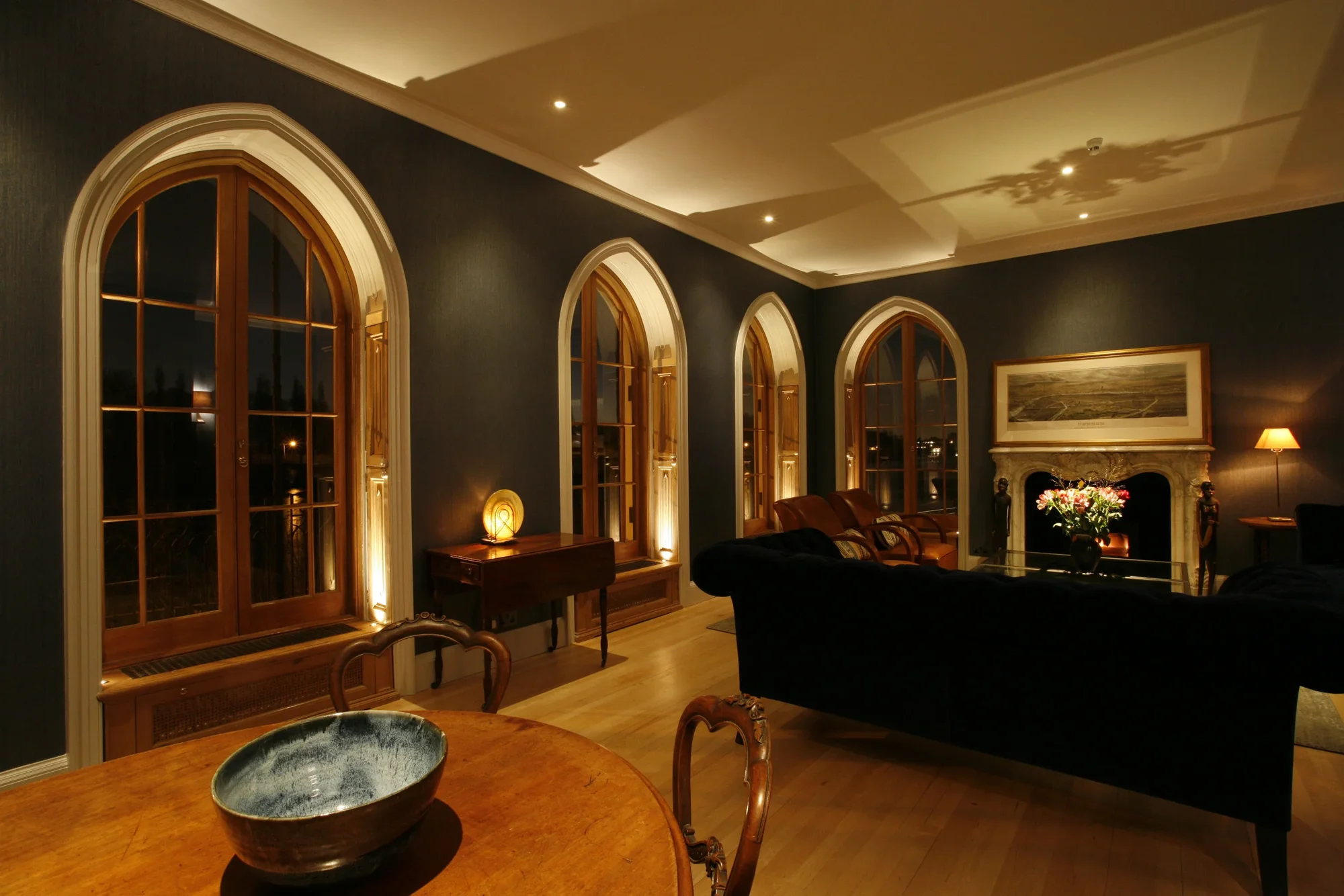 Warm architectural lighting across an arched residential living room
